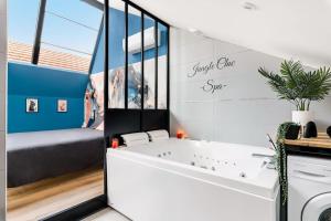 La salle de bains est pourvue d'une baignoire blanche. dans l'établissement Bienvenue à Jungle Chic, à Bourgoin-Jallieu
