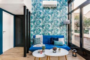 a living room with a blue couch and a table at Bienvenue à Jungle Chic in Bourgoin