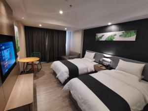 een hotelkamer met 2 bedden en een flatscreen-tv bij Thank Inn Chain Heyuan Zijin Baocheng Commercial Plaza in Zijin