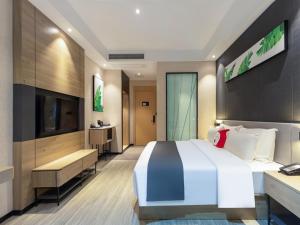 - une chambre avec un grand lit et une télévision dans l'établissement Thank Inn Chain Foshan Gaoming Road, à Gaoming