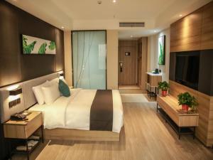 a hotel room with a large bed and a television at Thank Inn Chain Suqian Hubin New District Santaishan Park in Suqian