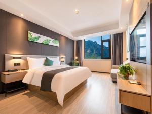 a bedroom with a large bed and a large window at Thank Inn Chain Jiaozuo Qinyang Qinbei Industral Cluster in Qinyang