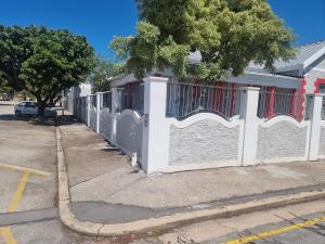 a white fence in front of a house at AIDEN'S GUEST HOUSE in Port Elizabeth