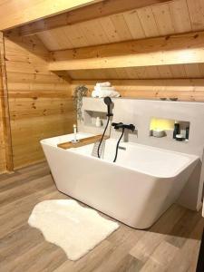 eine große weiße Badewanne in einem Holzzimmer in der Unterkunft NEW chalet de standing premium in Senones