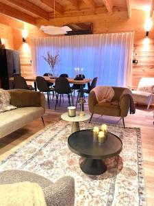 ein Wohnzimmer mit Sofas, einem Tisch und Stühlen in der Unterkunft NEW chalet de standing premium in Senones