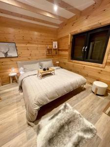 ein Schlafzimmer mit einem Bett in einer Holzhütte in der Unterkunft NEW chalet de standing premium in Senones
