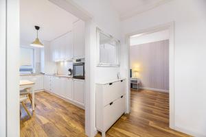 cocina con armarios blancos, mesa y ventana en KOA - Sunlight Apartment, en Brasov