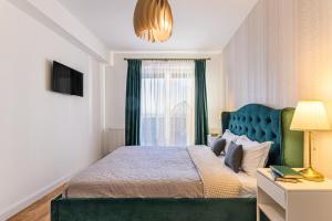 Un dormitorio con una cama verde y una ventana en KOA - Sunlight Apartment, en Brasov