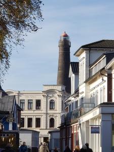 ボルクムにあるVilla Scherz - stilvoll, zentral, ruhig, EGの白い建物の上に建つ灯台