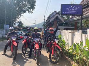 Un groupe de personnes qui roulent à moto dans une rue dans l'établissement Pimpa House, à Ban Hua Nam Mae Sakut