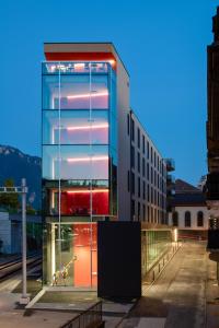 un bâtiment avec une façade en verre dans une ville dans l'établissement "The Freddie Mercury" Hotel, à Montreux