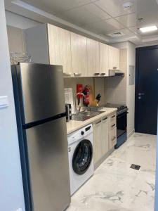 a kitchen with a refrigerator and a washing machine at StoneTree - Cozy and Modern 1 BR in Dubai