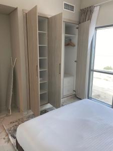 sypialnia z białym łóżkiem i oknem w obiekcie StoneTree - Cozy and Modern 1 BR w Dubaju