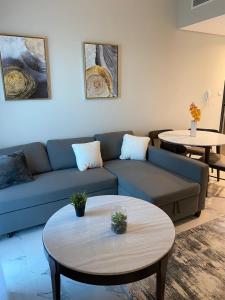 a living room with a blue couch and two tables at StoneTree - Cozy and Modern 1 BR in Dubai