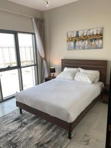 sypialnia z dużym łóżkiem z białą pościelą w obiekcie StoneTree - Cozy and Modern 1 BR w Dubaju