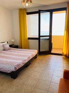 Schlafzimmer mit einem Bett und Glasschiebetüren in der Unterkunft Villa Sun Palace in Sweti Wlas