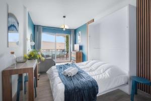 ein Schlafzimmer mit einem Bett, einem Tisch und einem Schreibtisch in der Unterkunft L'Ecrin Bleu Parking-Clim-Cosy in Sète