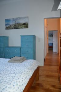 ein Schlafzimmer mit einem Bett und einer blauen Kommode in der Unterkunft Villa Scherz - stilvoll, zentral, ruhig, EG in Borkum