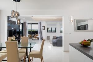 a dining room and living room with a glass table and chairs at Apartments Sara II in Ližnjan