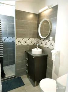 a bathroom with a sink and a toilet and a mirror at Le Patio - Saint-Denis d’Oléron in Saint-Denis-dʼOléron