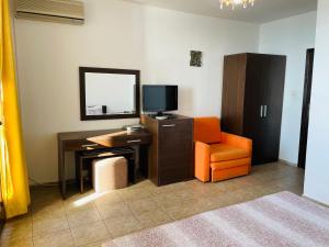 a room with a desk and a chair and a television at Villa Sun Palace in Sveti Vlas