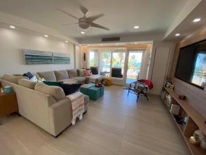 a living room with a couch and a flat screen tv at Luxury Beachfront 2 Bedroom at Wyndham Rio Mar, PR in Luquillo