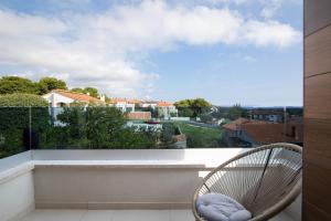 a balcony with a chair and a view at Apartments Sara II in Ližnjan