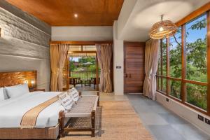 una camera da letto con un letto e una grande finestra di Sanctuary Chitwan National Park a Chitwan