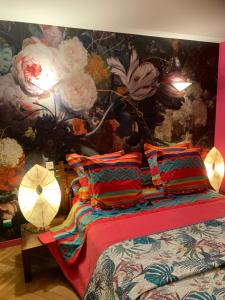 um quarto com uma cama com uma parede floral em Chez Ghislaine et Robert 