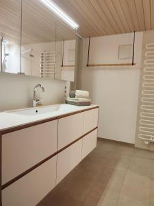 a kitchen with white cabinets and a sink at Landwohnung in Lingenau
