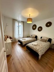 ein Wohnzimmer mit 2 Betten und einem Sofa in der Unterkunft Le refuge Champenois in Verneuil