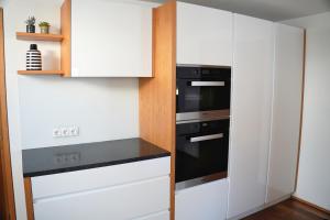 a kitchen with white cabinets and a black oven at Landwohnung in Lingenau