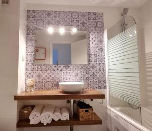 y baño con lavabo, espejo y toallas. en www Casa Quili Cádiz com en Cádiz