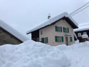 een berg sneeuw voor een huis bij Chalet del Sole in Quinto