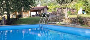 uma piscina em frente a uma casa em Casa O Corvo, chalet cerca de Vigo en plena naturaleza 