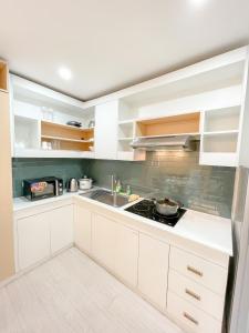 eine Küche mit weißen Schränken und einem Waschbecken in der Unterkunft Travelers Inn - Modern Capsule Bunks, Makati in Manila