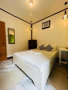 a bedroom with a white bed with two pillows at Anaya Inn and Restobar in Panglao