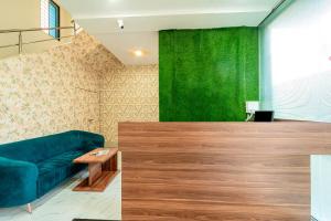 a living room with a couch and a green wall at Itsy By Treebo - Anand Executive, Near Amanora in Pune