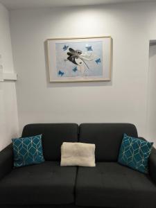 un divano nero in soggiorno con una foto sul muro di l'odyssée a Sarreguemines