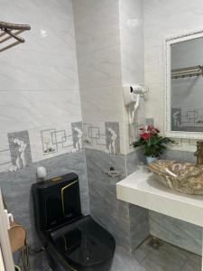 a bathroom with a toilet and a sink and a mirror at Nhà Nghỉ Huyền Anh in Hanoi