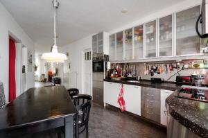 a kitchen with a black counter top and white cabinets at Apartment Sandra in Amsterdam