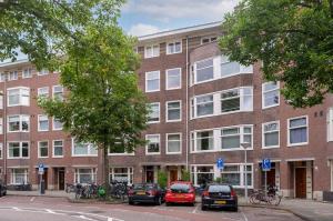 un edificio de ladrillo con coches estacionados frente a él en Apartment Sandra en Ámsterdam