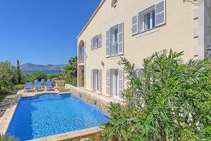 a house with a swimming pool next to a house at Villa AMOROS in Alcudia