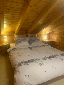 uma cama num quarto com tecto em madeira em Chalet typique tout confort avec studio en dessous em Hérémence