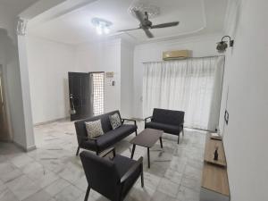 salon z kanapami i krzesłami oraz wentylatorem sufitowym w obiekcie Home Sweet Home w mieście Sungai Petani