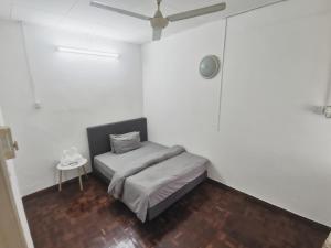 sypialnia z łóżkiem i wentylatorem sufitowym w obiekcie Home Sweet Home w mieście Sungai Petani