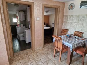 a kitchen and dining room with a table and chairs at Lakeside oasis home Karuc in Karuč