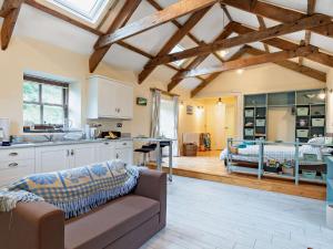 a kitchen and living room with a couch and a bed at Tiptoe Barn in Liskeard