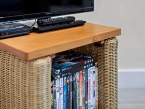 a table with dvds and a tv on top at Tiptoe Barn in Liskeard