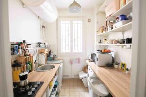 a small kitchen with a sink and a counter top at Proche métro Nid Parisien - 11e in Paris